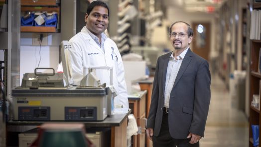 Two men standing in a research lab inside the Georgia Cancer Center's M. Bert Storey Research Building.