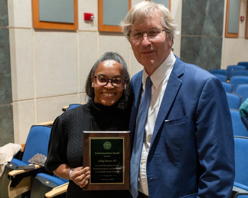 Man standing with a woman who is holding an award