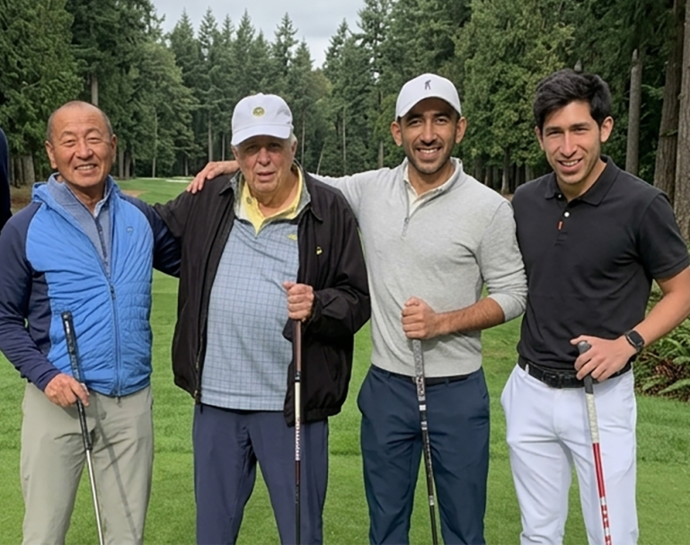 four men stand with golf clubs