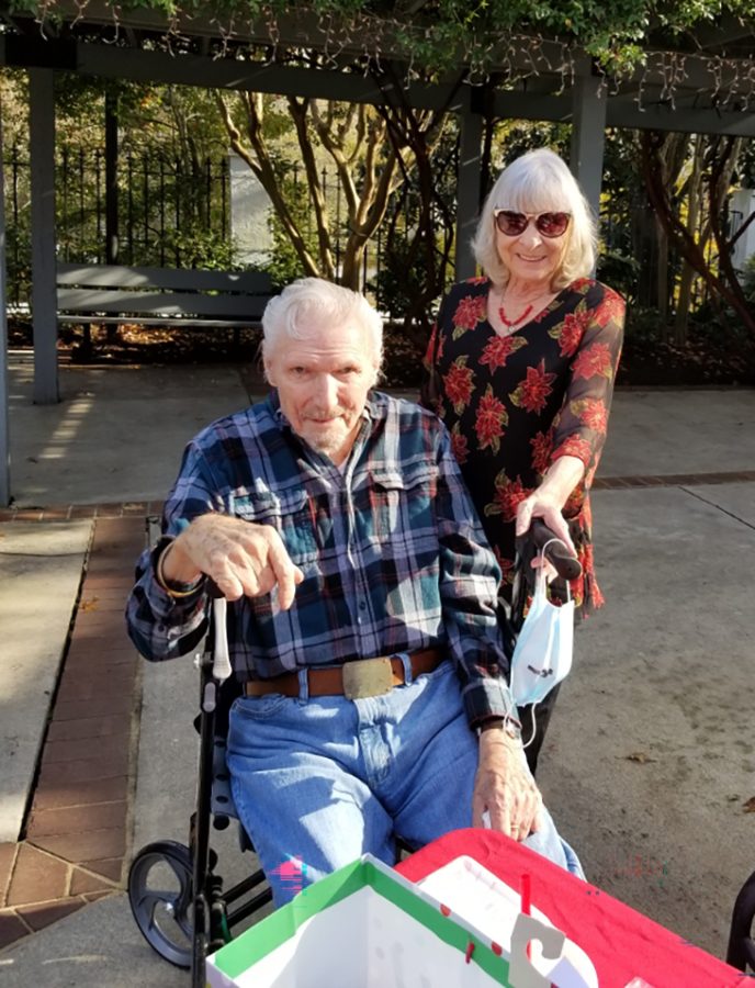 Woman standing next to  a man in a wheelchair
