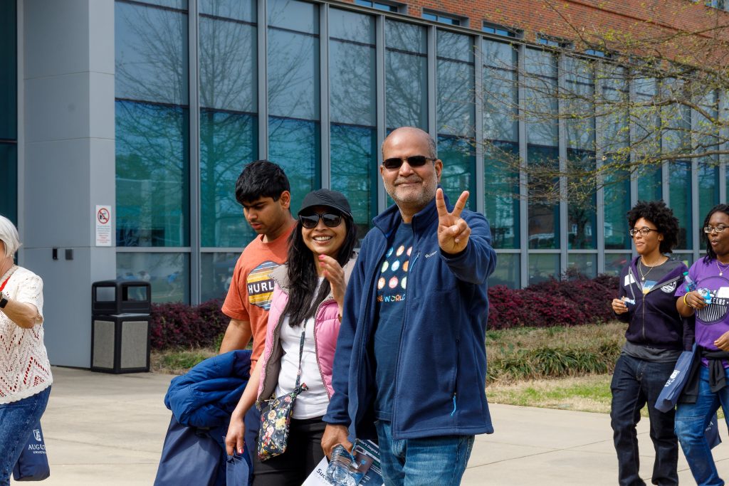 A man holds up two fingers to imitate a peace sign.