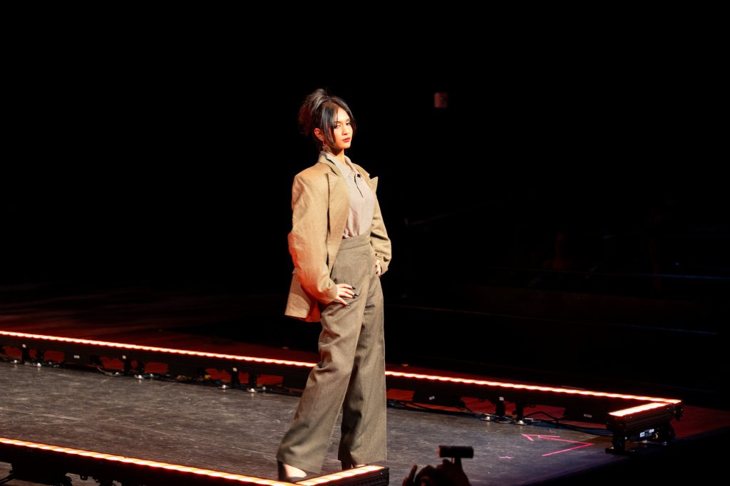 A woman poses at the end of a runway