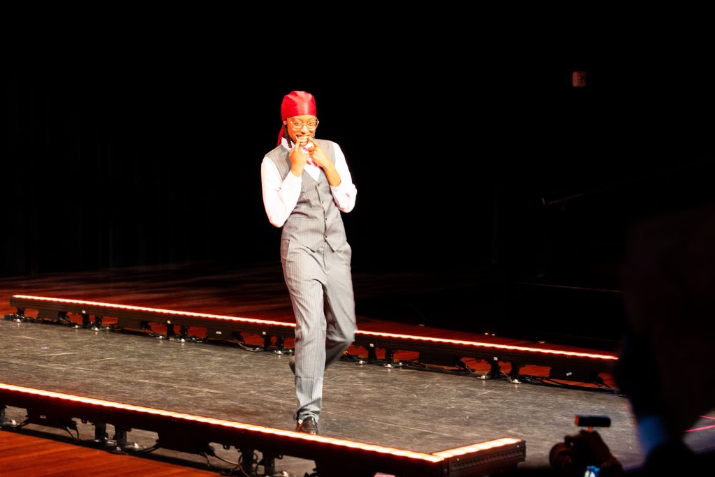 A woman poses at the end of a runway