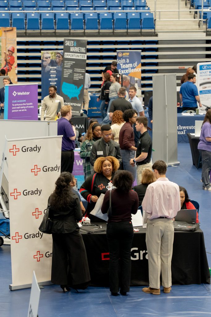 Various people gathered at a tabling opportunity for a hospital.