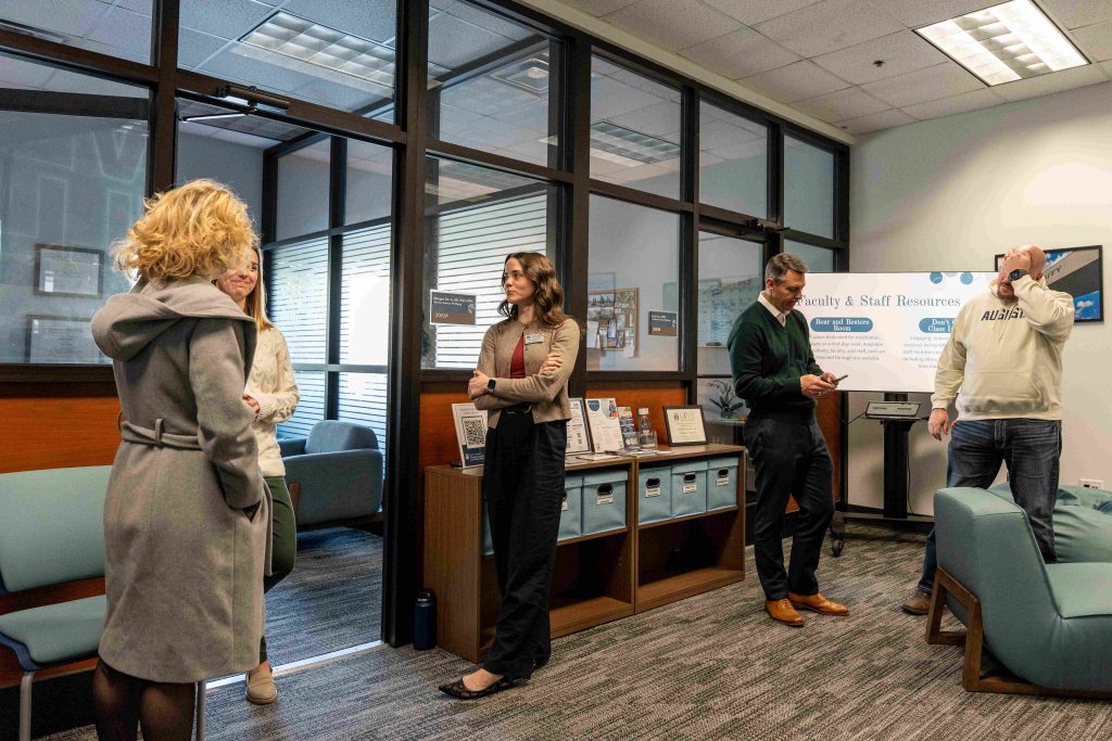 Two men and two women talking amongst one another within an office space.