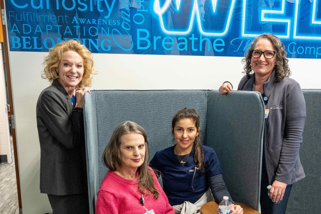 Four women smiling for a photo. 