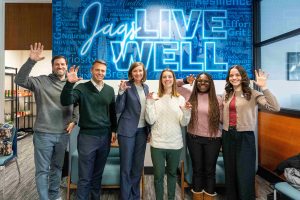 Several men and women hold up their hands in a paw pose.