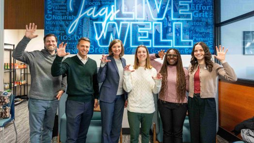 Several men and women hold up their hands in a paw pose.