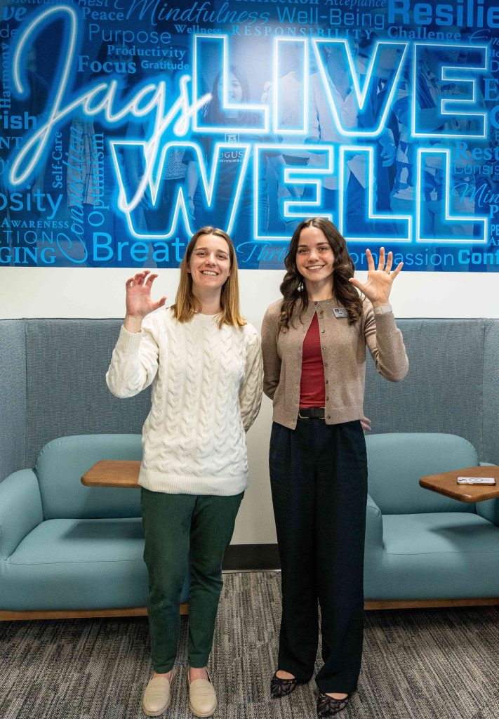 Two women hold up their hands to mimic a paw pose.