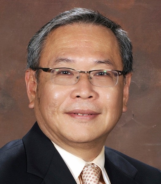 A dental researcher and professor smiles at camera