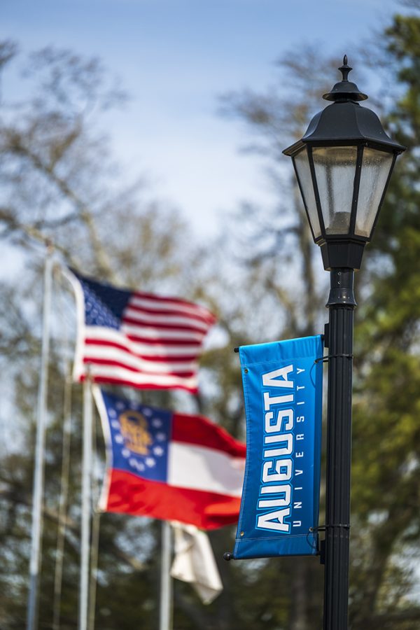 A light pole with Augusta University banners hanging on them