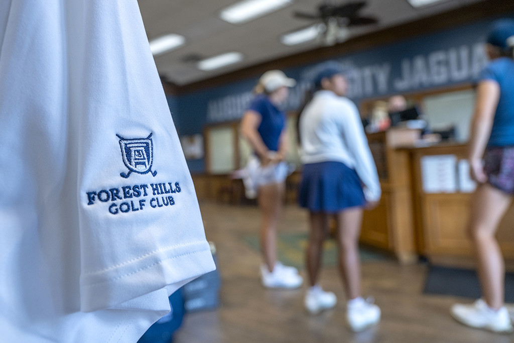 Women standing in the pro shop in front of clothing