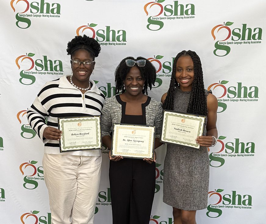 Three women standing with certificates.