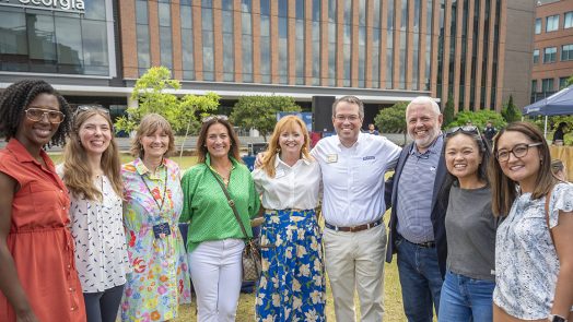 Smiling people outside on a college campus