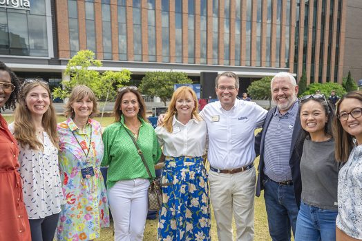 Smiling people outside on a college campus