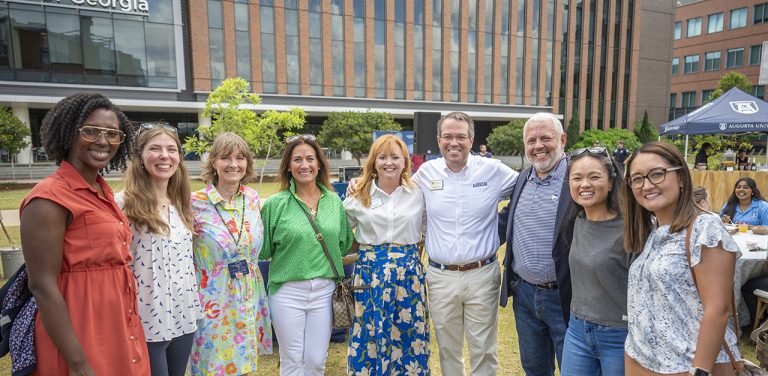 Smiling people outside on a college campus