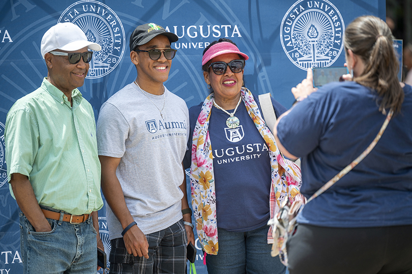 Family posing for a photo in front of blue backdrop