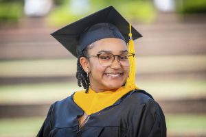 A woman smiles while posing for graduation photo