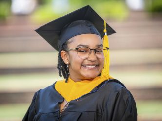 A woman smiles while posing for graduation photo