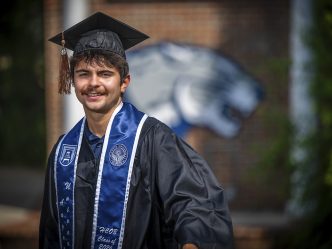 A man smiling with a cap and gown on