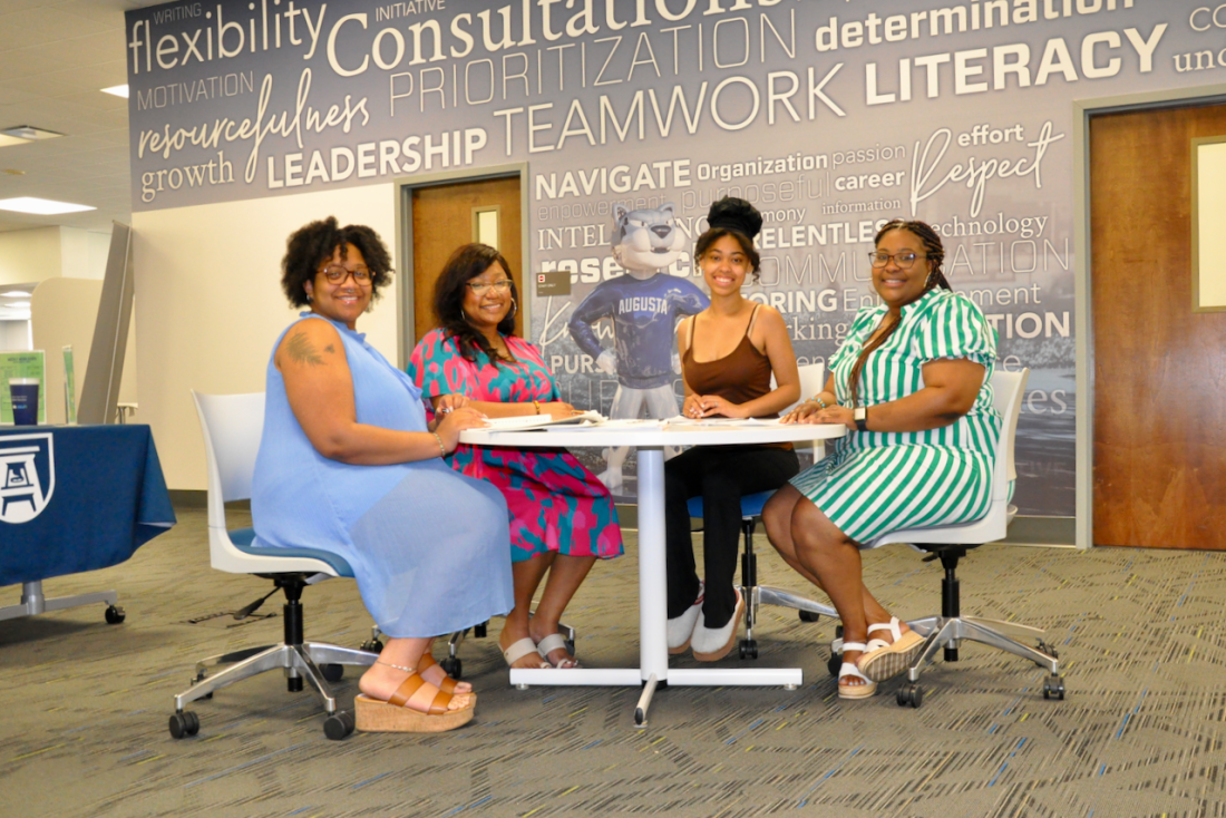 Four women sitting around a table at a meeting