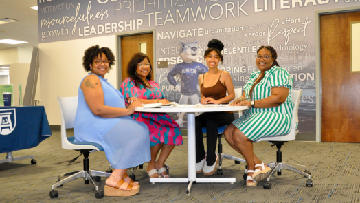 Four women sitting around a table at a meeting