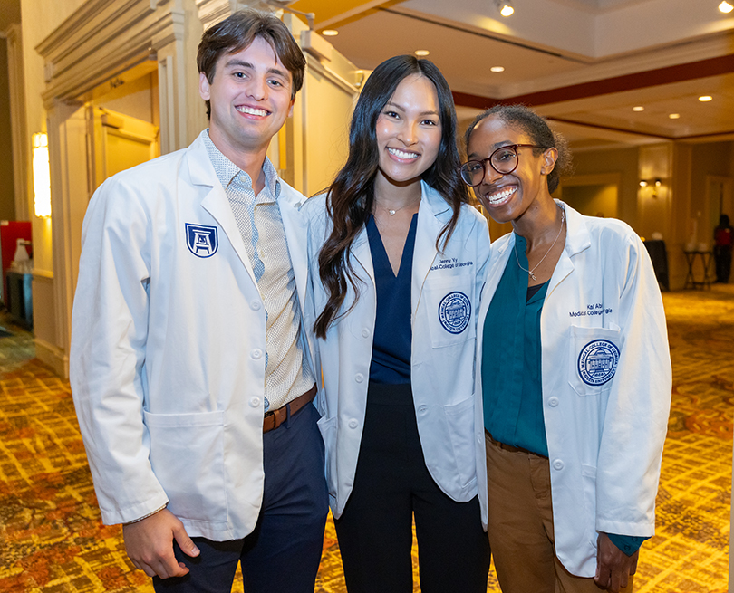 Medical school students in white coats smiling