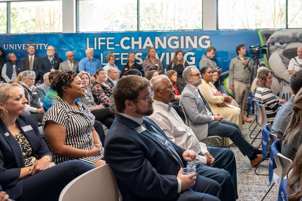 A large crowd of seated men and women at an indoor event.