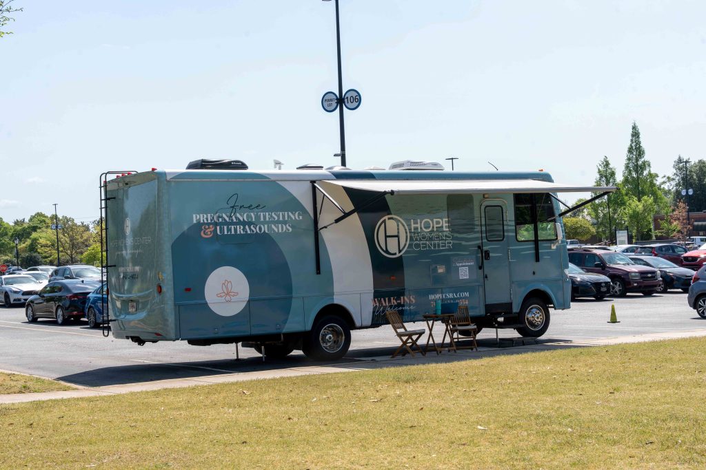A recreational vehicle for on-the-go health services parked on a curb.