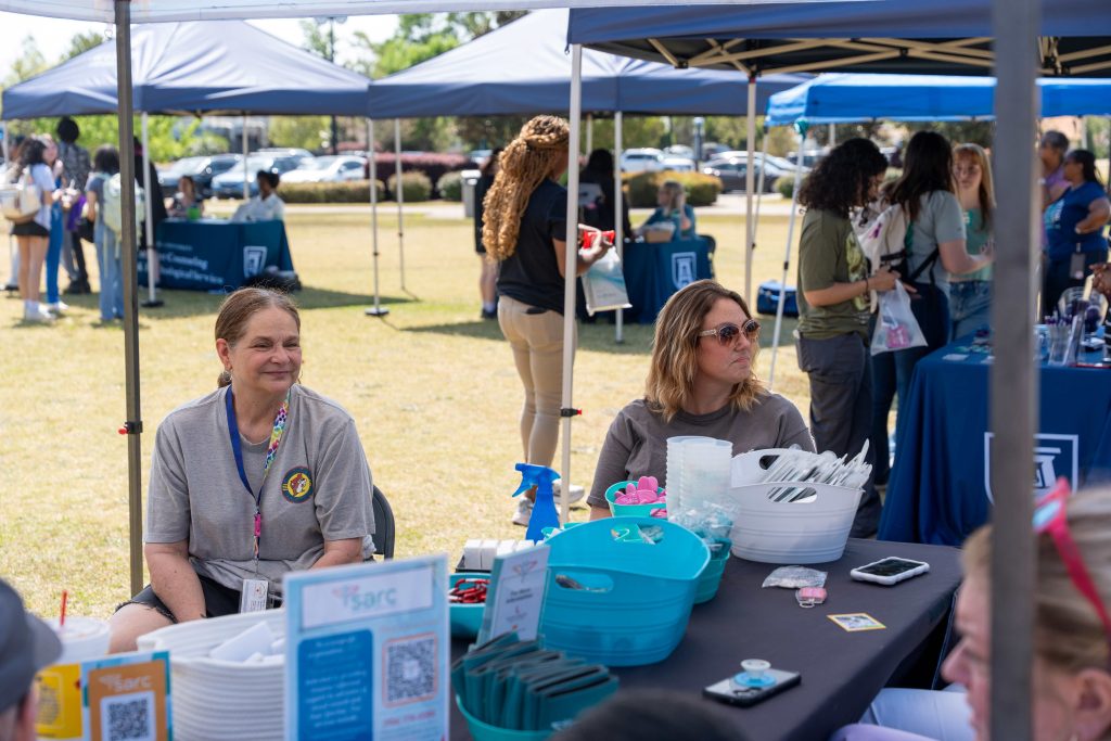 Tabling participants smiling at guests.