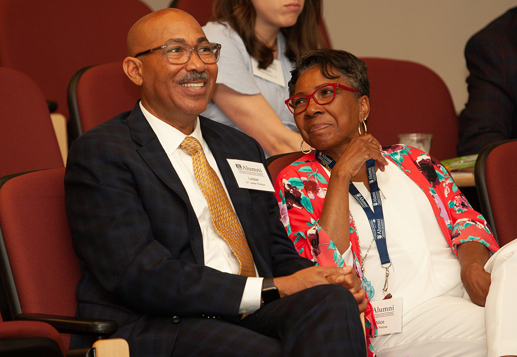 A man and a woman sitting down smiling