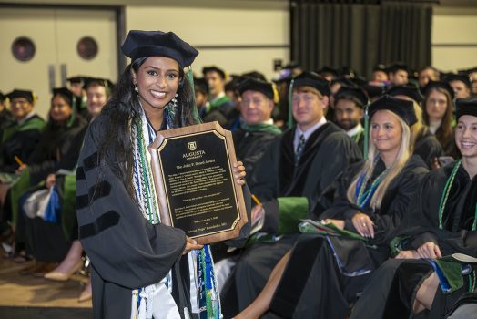 woman holds plaque