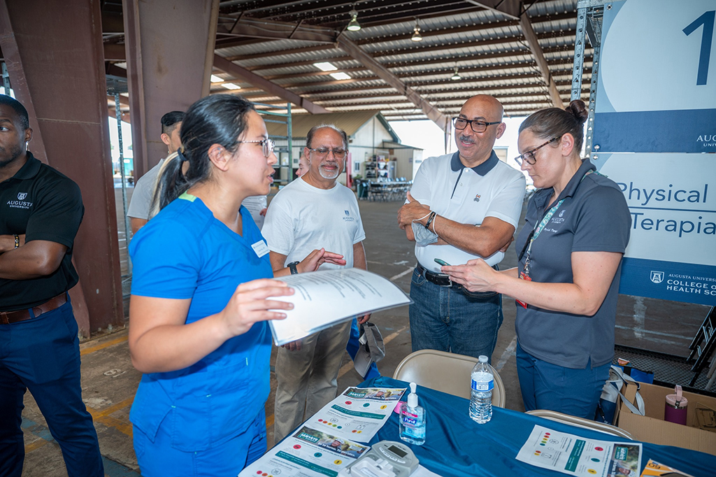 Men and women talking at a booth during a health fair