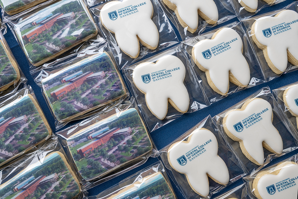 Cookies with a building rendering stamped on them, and tooth-shaped cookies with "Dental College of Georgia Savannah" stamped on them.