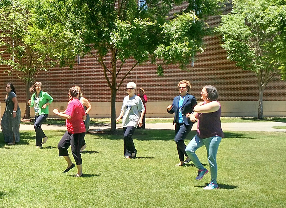 Women standing on the grass doing exercises