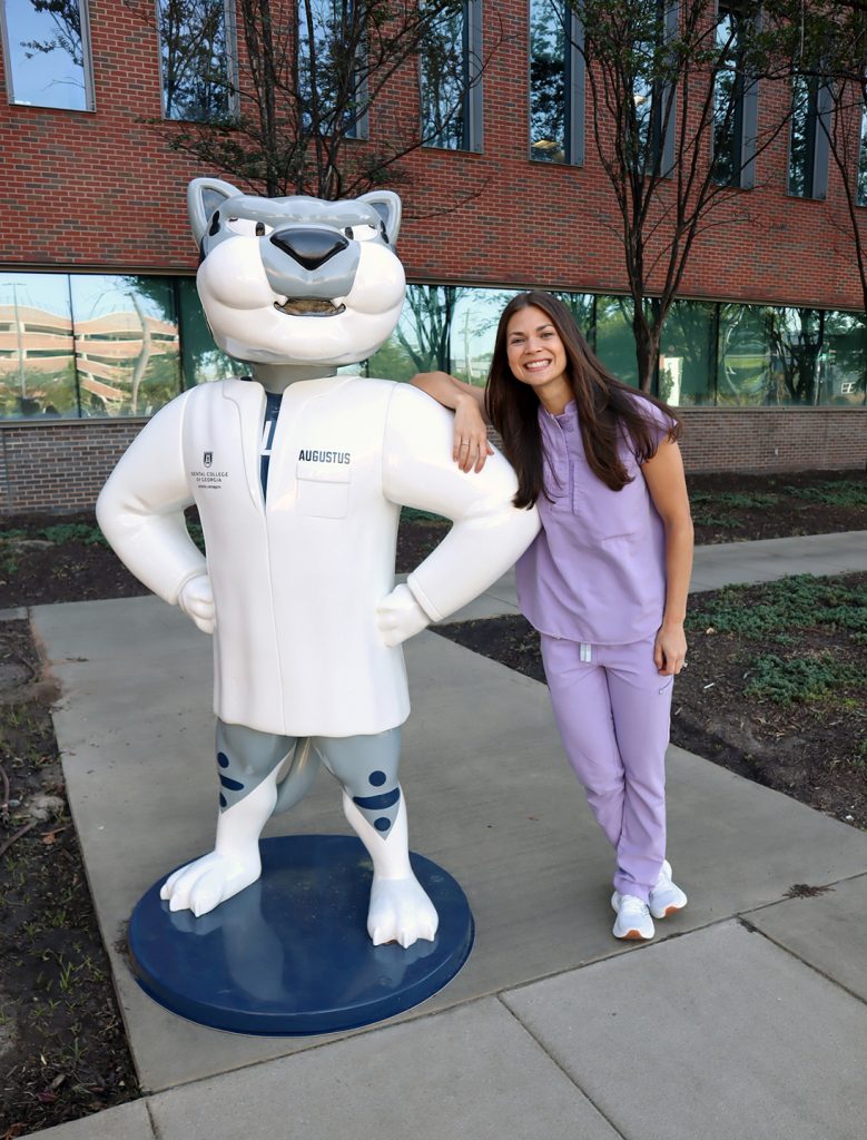 Orthodontics resident leans on the school mascot