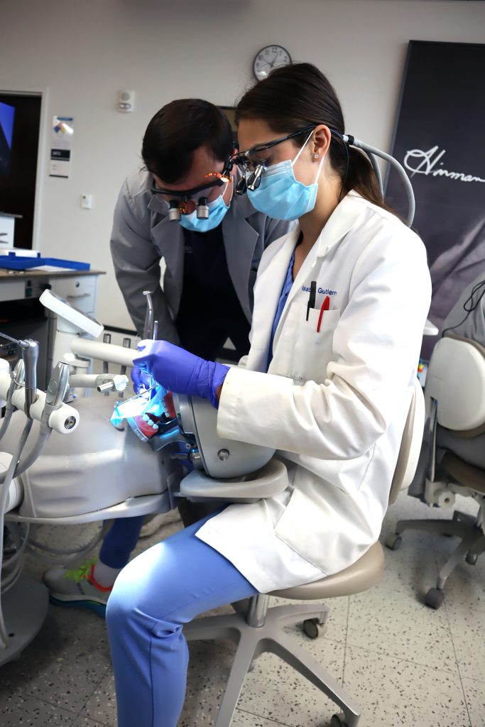 Dental senior tutors underclassman in dental simulation lab.