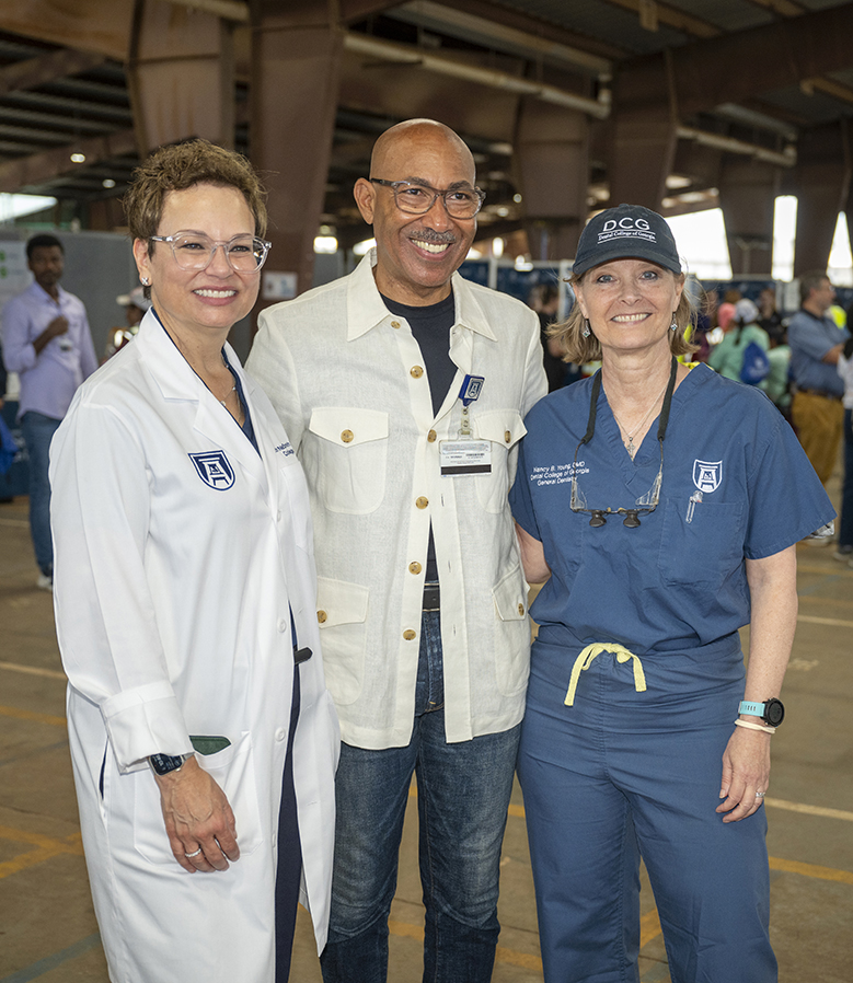Two women posing for a photo with a man