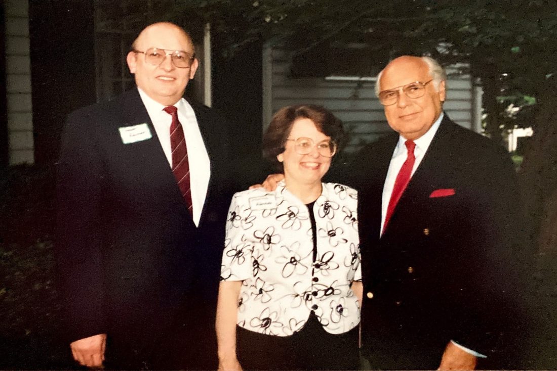 A woman standing with two men