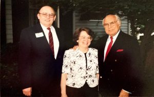 A woman standing with two men