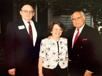 A woman standing with two men
