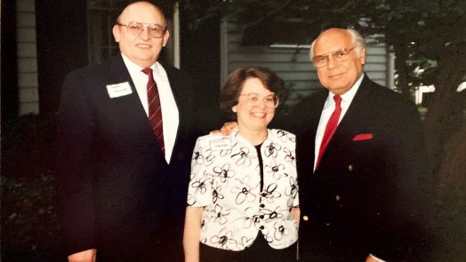 A woman standing with two men