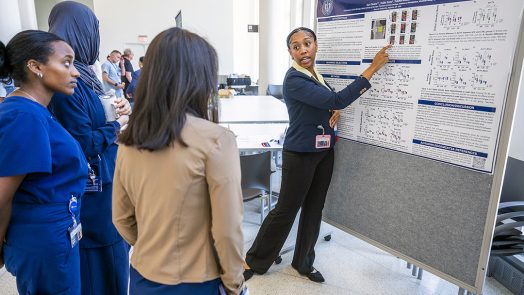 Student explains her research to onlookers