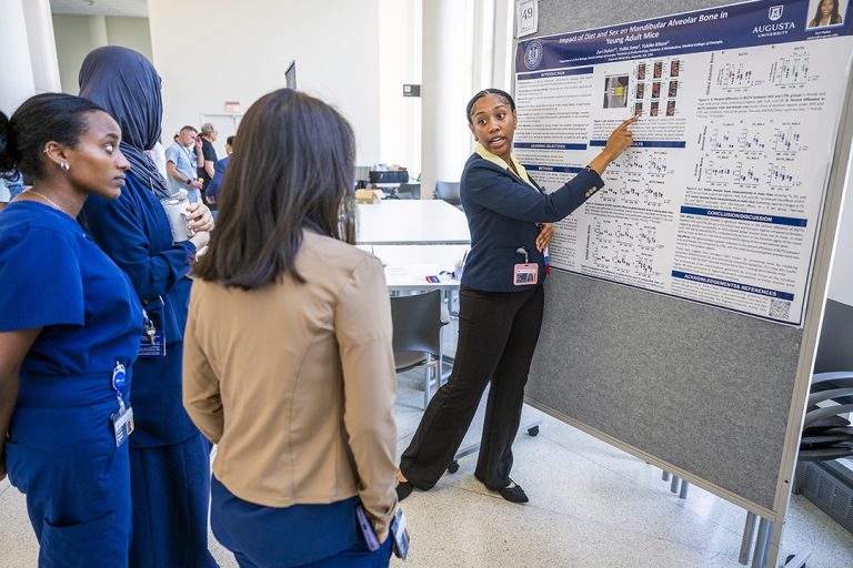 Student explains her research to onlookers