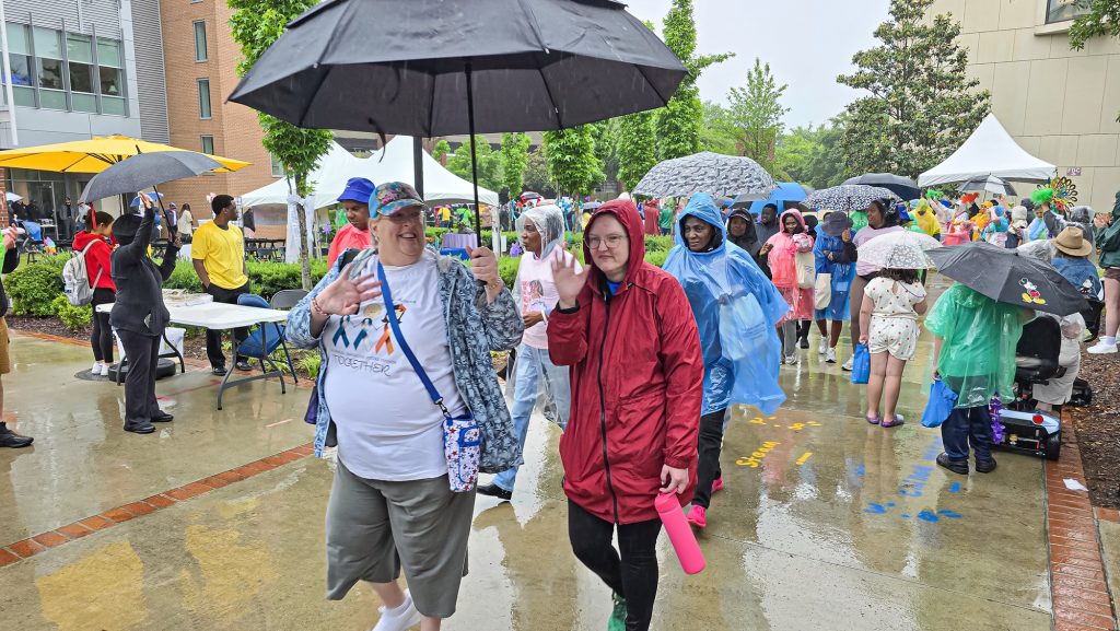In this photo, you see people walking down a street. The people are participants in the Georgia Cancer Center's Unite in the Fight Against Cancer 2026 community event.