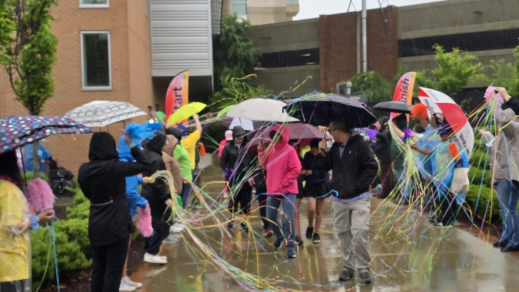 In this photo, you see people walking down a street. The people are participants in the Georgia Cancer Center's Unite in the Fight Against Cancer 2026 community event.