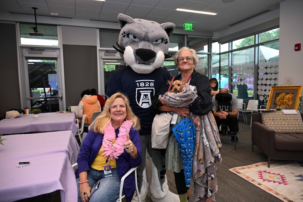 In this photo, you see people posing for a photo with Augustus, Augusta University's Jaguar mascot.
