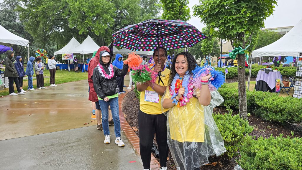 In this photo, you see two people standing under umbrellas and posing for the picture.