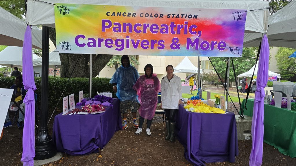 In this photo, you see people posing for a photo under a tent.