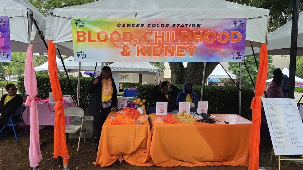 In this photo, you see people posing for a photo under a tent.